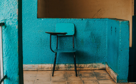old-fashioned school desk on a teal wall