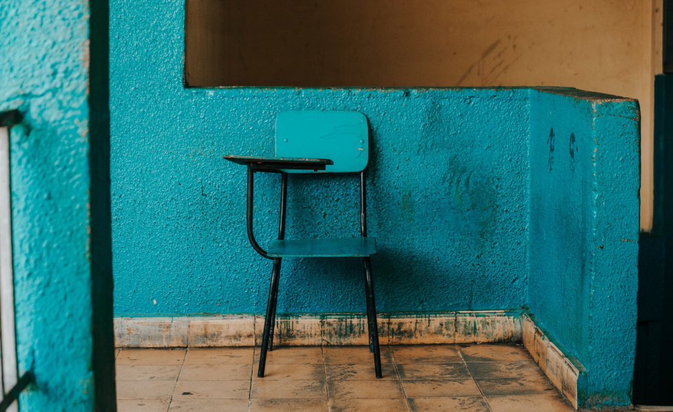old-fashioned school desk on a teal wall